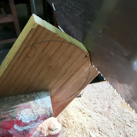 Cutting a circular piece of wood with a hand saw