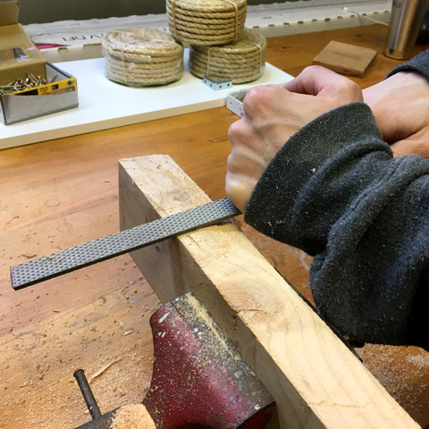 Rasping a piece of wood to round the edges